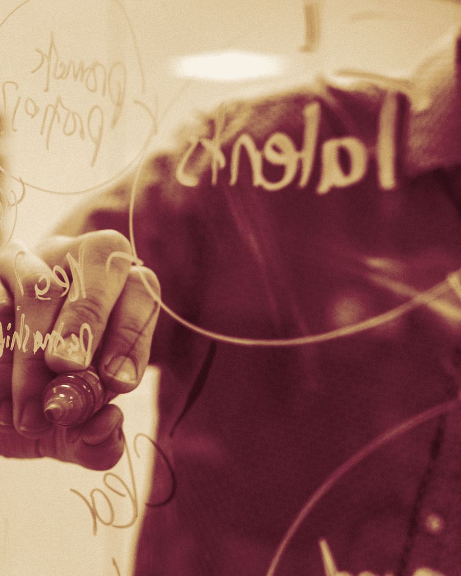 An architect drawing diagrams on a glass wall