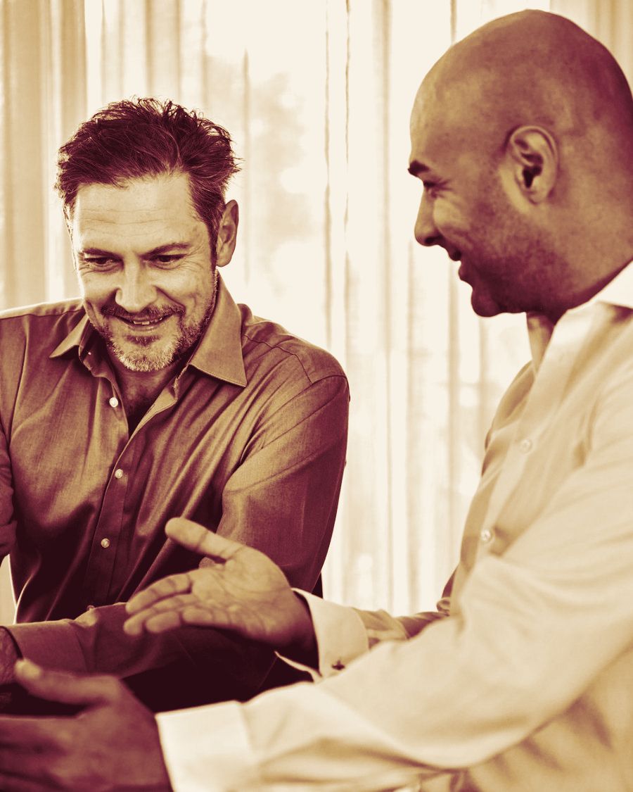 Two colleagues discussing a plan at a laptop