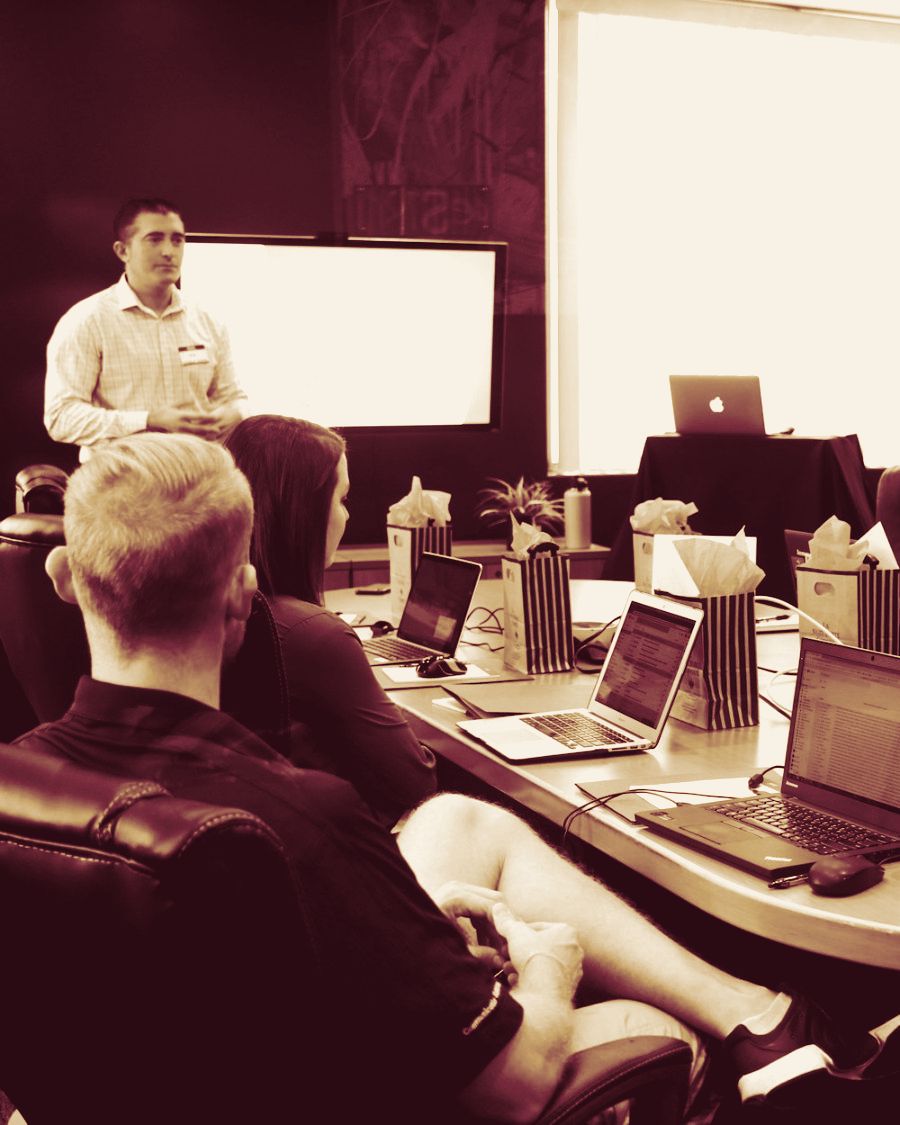 A presenter leading a meeting at a long table